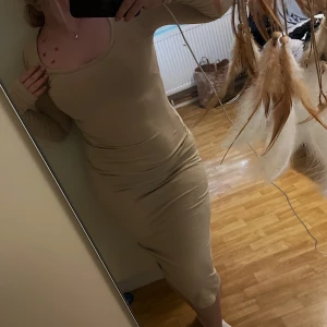 Beige klänning  - Beige klänning från Boohoo. Väldigt skönt material, stretchig och sitter snyggt mot kroppen, Storlek 40, men jag är 38 och den passar mig bra!