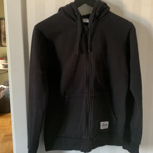 Svart hoodie från Frank Dandy - Säljer en svart hoodie från Frank Dandy, perfekt för höst och vinter. Den har en dragkedja framtill och en mysig huva med snörning. Fickor på magen för extra komfort. Passar både till vardags och chillkvällar. 🖤pris kan diskuteras!