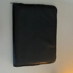 Svart datorfodral läder från Åhléns  - 35x26cm, inte använt så mycket då min dator inte passade i den. Det är svart flätat läder runt hela.