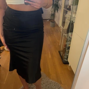 Svart Silkeskjol NAKD - Jättefin kjol i silkesliknande material från NAKD. Sparsamt använd. Strl 36