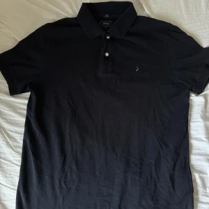 Boomerang Piké - Mörkblå Boomerang Piké i storlek M. Den är använd några gånger men fortfarande i bra skick och har fortfarande kvar extraknappen (se sista bilden).