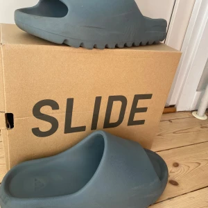 Yeezy Slides  - Säljer mina autentiska Yeezy slide slate marina som jag köpt på droppet för 900kr totalt. Skick:8/10