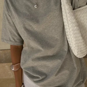 Grå t-shirt från NA-KD - Säljer en snygg grå t-shirt från NA-KD i storlek XS. Den är i  färgen ’Grey Melange” och har en rund hals. Perfekt för en avslappnad look! Helt oanvänd; originalpris 199kr