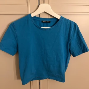 Blå t-shirt från Zara - Blå kortare tshirt från Zara, mycket bra skick och endast använd ett fåtal gånger, skulle säga att den passar xs-s, skriv privat för fler bilder eller vid frågor❣️