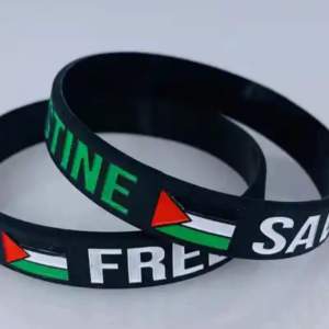 Säljer ett svart armband med texten 'FREE PALESTINE' i grönt och vitt. Armbandet har också en flagga som detalj. Perfekt för att visa ditt stöd!!!