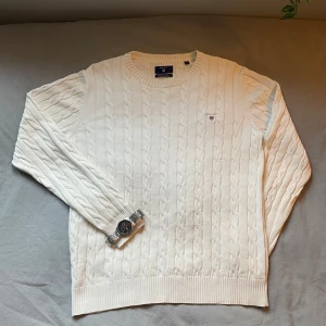 Cream färgad kabelstickad tröja från Gant - Tröjan är i väldigt bra skick och perfekt nu när det är kallare ute. Om ni har några frågor så är det bara att ställa dom🤗 Axelbrädden är 45cm och länden är 64 cm👌