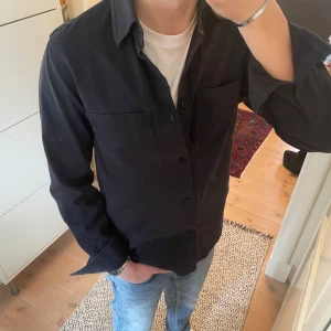 Marinblå overshirt - Säljer en riktigt snygg over shirt från arket i storleken 46 som man kan gem föra med ungefär S. Overshirt en är i väldigt bra skicka och inga defekter finns. Om man har några frågor så är det bara att skriva🤗