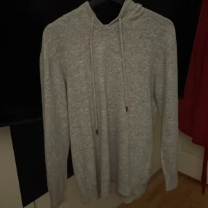 Grå merinoull hoodie - Säljer en stilren grå merinoull hoodie i väldigt bra kvalité och är gjord i ett mjukt material som känns skönt mot huden. Snygg passar till allt!! 