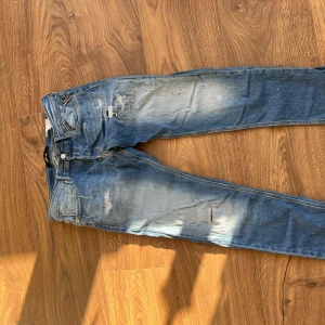 Replay jeans - Snygga blå jeans från Replay med en regular slim fit. De har en sliten look med ljusa partier och små revor för en trendig stil. Perfekta för en avslappnad och cool outfit. Topp skick, inga defekter! Pris: 400