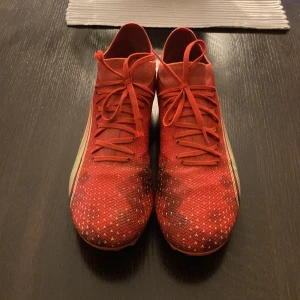 Röda fotbollsskor från Puma - Snygga, näst intill oanvända fotbollsskor från Puma med snörning på. Passar för dig som vill ha lite extra grepp med bollen.                                              Pris kan diskuteras 