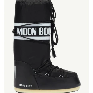 Svarta Moon Boots - Snygga och trendiga svarta Moon Boots med vit logga och snörning. Perfekta för vintern med sin unika design och bekväma passform. De har en hög profil och en robust sula som ger bra grepp på snöiga underlag. Köpte för 2000 säljer för 1300. Skriv för fler bilder och mer.