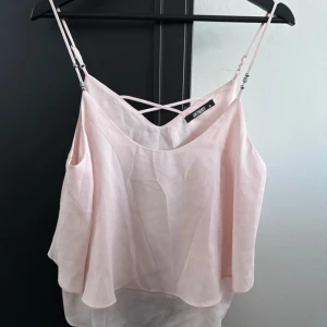 Ljusrosa linnetopp från Hollies - Säljer en söt ljusrosa linnetopp från Hollies. Toppen har tunna axelband och en luftig passform med dubbla lager tyg. Perfekt för varma dagar eller som ett lager under en kavaj.