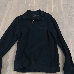 Svart långärmad tröja med dragkedja - Säljer en stilren svart långärmad tröja från Patagonia. Tröjan har en praktisk dragkedja vid halsen och en diskret bröstficka. Perfekt för kyligare dagar.