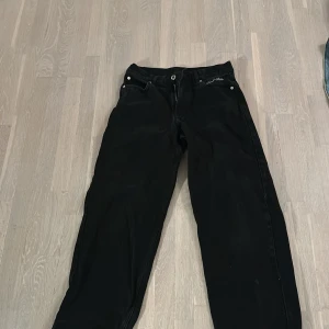 Svarta jeansbyxor - Snygga svarta jeansbyxor med klassisk femficksdesign och knappgylf. Perfekta för en stilren look. Passar till många olika outfits.