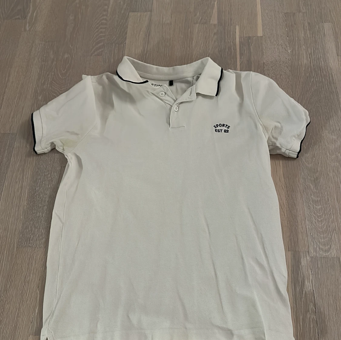 Vit pikétröja med svart kant