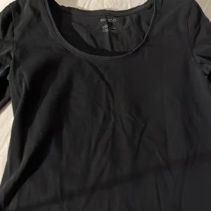 Svart långärmad topp från Esmara - Säljer en stilren svart långärmad topp från Esmara. Perfekt basplagg med rund halsringning, passar till många olika outfits. Skön och enkel design för en avslappnad look.