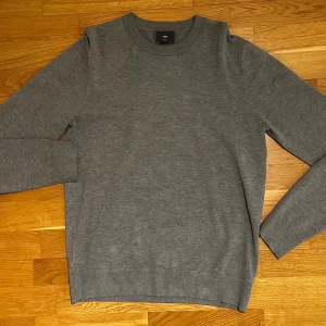 Grå tröja från H&M - Säljer en stilren grå tröja från H&M. Tröjan har en klassisk rund hals och långa ärmar, perfekt för en enkel och snygg look. Storlek S. Nyskick!