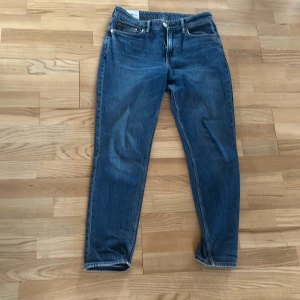 Blå jeans storlek 30/32  - Klassiska blå jeans med fem fickor och knappgylf. De har en rak passform och är perfekta för en avslappnad stil. Jeansens sömmar är i kontrasterande färg vilket ger en snygg detalj.