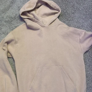 Beige hoodie - Säljer en mysig beige hoodie med känguruficka framtill. Perfekt för en avslappnad stil och passar bra till både jeans och mjukisbyxor. Huvan ger extra värme och komfort.