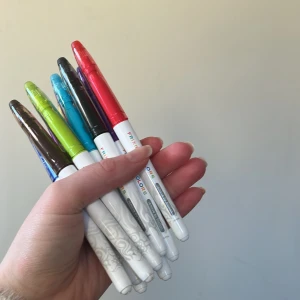 Färgglada pennor från FriXion Colors - Säljer ett set med färgglada pennor från FriXion Colors. Pennorna har vita kroppar med olika färgade lock i rött, blått, grönt, gult, rosa, brunt och svart. Perfekta för att skriva eller rita med stil och precision. 🖊️✨priset gäller alla 10 stycken, flesta har legat i storage och ska fungera utan problem!