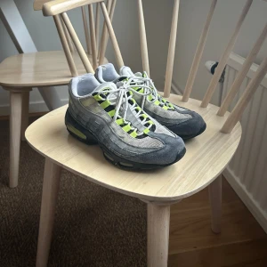 Nike Air Max 95 neon - Säljer ett par Nike Air Max 95 sneakers i grått med neongula detaljer. Skorna har en ikonisk design med synlig Air-dämpning i sulan och snörning framtill. Perfekta för en sportig look. Priset kan prutas eftersom att dom är lite smutsiga 