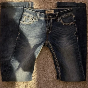 lågmidjade bootcut jeans - Ordinarie pris 900kr! Snygga mörkblå lågmidjade utsvängda jeans med tydliga kontrastsömmar och en unik design! Helt nyskick!! Passar verkligen till allt och extremt snygga jeans🥰❣️ kontakta mig för mått och andra funderingar! 