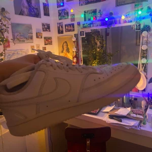 Vita Nike sneakers - Säljer ett par klassiska vita Nike sneakers med snörning. Detta pågrund av att jag växt ur dem. Skorna är stilrena och perfekta för en avslappnad och sportig look. De är i bra skick. Köpare står för frakt👍💕