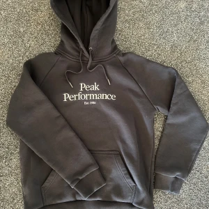 Peak Performance hoodie - säljer nu min Peak Performance hoodie då jag inte får nån nytta av den längre / väldigt bra skick / storlek M men sitter nästan som S/XS då den krympt i tvätten men passar dig runt 160-170 cm lång / cigg fri och husdjursfritt hus så inga konstigheter / Snabb affär = bättre pris, nypris ca 1100kr / hör av dig vid minsta fundering💯