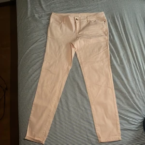 Låg bidjade Ljusrosa byxor  - Snygga ljusrosa byxor med dragkedja och knapp framtill. Byxorna har en stilren design med fickor både fram och bak. Perfekta för en chic och avslappnad look. Den är 94 cm lång och är lågbidjat. Har aldrig använt den❤️