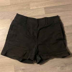 Svarta shorts från H&M - Snygga svarta shorts från H&M med dragkedja och knappstängning. De har en klassisk design med två bakfickor och hällor för bälte. Kom gärna med prisförslag!😁