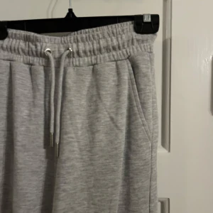 Grå mjukisbyxor - Säljer ett par bekväma grå mjukisbyxor med elastisk midja och dragsko. Byxorna har en loose passform och är perfekta för en avslappnad stil. De har även praktiska sidofickor. Passar xs-s