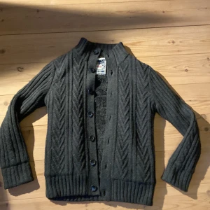 Stickad cardigan med päls  - Riktigt snygg och unik, knappar hela vägen upp vilket är riktigt snyggt och sen är fodrad. Sitter som s/m