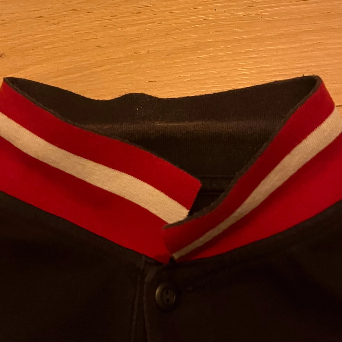 Svart pikétröja med röd broderad detalj - 2