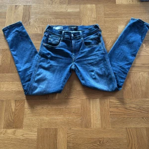 Blå jeans från Replay - Snygga blå jeans från Replay i modellen Anbass. De har en klassisk femficksdesign och en bekväm passform. Perfekta för en avslappnad stil. Va inte rädd att ställa frågor😁