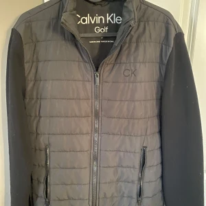 Svart jacka från Calvin Klein Golf - Säljer en stilren svart cardigan jacka från Calvin Klein. Jackan är i storlek S. Ärmarna är långärmade och tillverkade i ett mjukt material. Den är lite nopprig på ärmarna och på en del av ryggen med det kan jag lätt ta bort innan köp!😊 Om du är intresserad av jackan är det bara att höra av dig!🥂