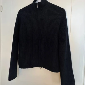 Svart stickad kofta med dragkedja - Säljer denna svarta stickade koftan från Bik Bok i nyskick!