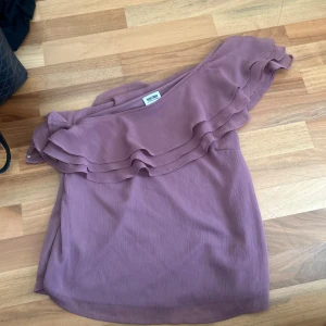One shoulder volang topp - Så fin one shoulder volang topp i en jätte fin lila färg, knappt använd i så bra skick! Insydd så passar xs och s ❤️