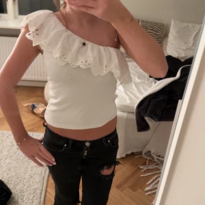 Vit offshoulder topp med spetsdetaljer - Säljer en söt vit offshoulder topp med spetsdetaljer och volang. Säljs inte från Zara längre, barnstorlek 164 men passar mig som brukar ha xs