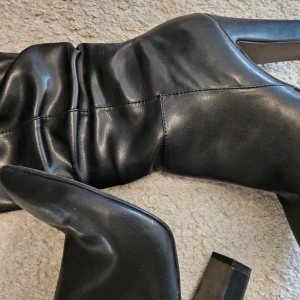 Tamaris Svarta stövletter - Snygga svarta stövletter från Tamaris med spetsig tå och klack. Perfekta för höst och vinter, dessa boots har en stilren design som passar både till vardags och fest. De är i mycket bra skick.