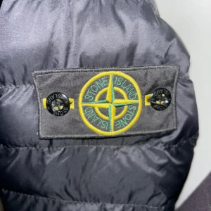 Svart pufferjacka från Stone Island - Säljer en snygg svart pufferjacka från Stone Island i storlek S. Köpte den på Vinted men säljer den igen för hållet i höger fickan. Skriv vid frågor och pris går att diskutera vid snabb affär🔥🔥