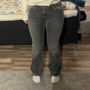 Grå jeans från Gina Tricot - Säljer ett par snygga grå jeans från Gina Tricot i storlek 164. De har en klassisk femficksdesign med coola broderade detaljer på bakfickorna. Jeansen är i bra skick och har en straight passform som passar perfekt till vardags. Perfekta för höst och vår!