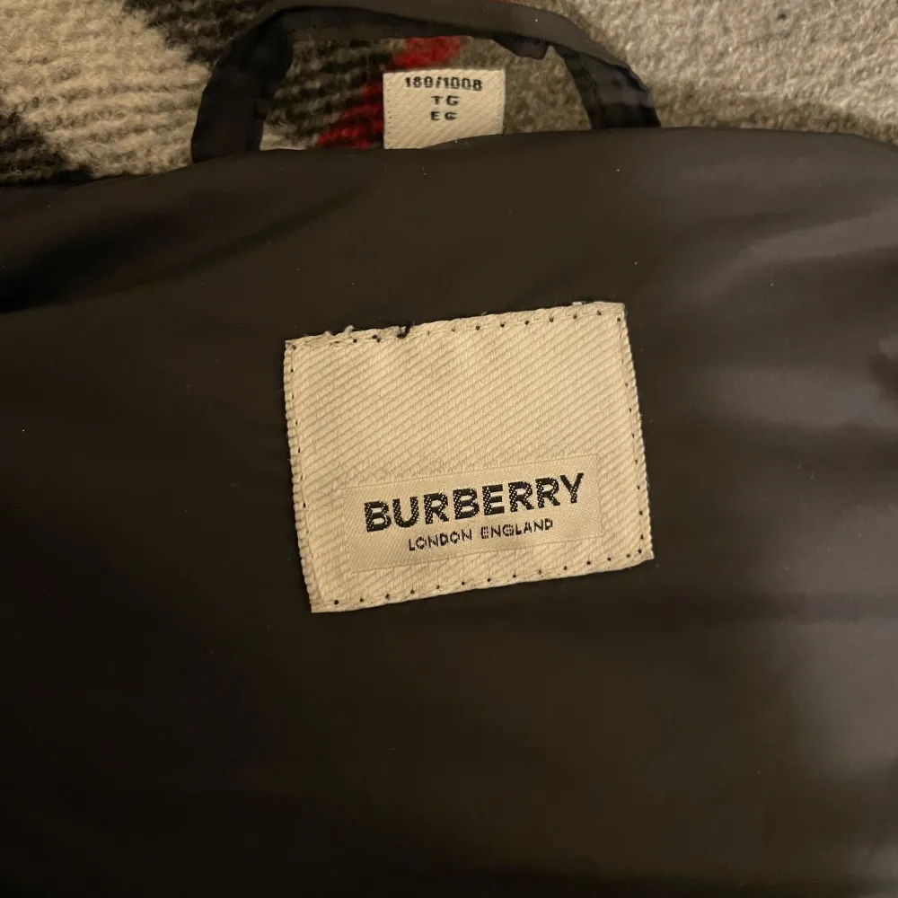 Säljer en snygg svart pufferjacka från Burberry i mycket bra skick. Jackan har avtagbara ärmar, vilket gör den till en väst också. Den har en dragkedja och knappar framtill, samt en huva med ett klassiskt Burberry-rutigt mönster. Perfekt för kalla dagar! 🖤 pris kan diskuteras!!! . Jackor.