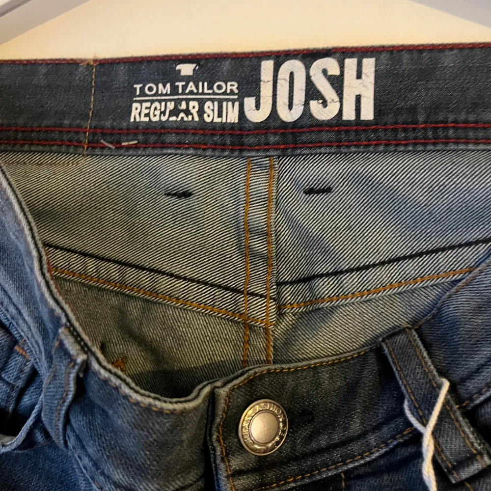 Säljer ett par snygga blå jeans från Tom Tailor, modell Josh. De har en regular slim passform och är i bra skick. Perfekta för både vardag och fest! De är tillverkade i slitstarkt denim och har en snygg tvättad look. Storlek 30/34. Jeans & Byxor.