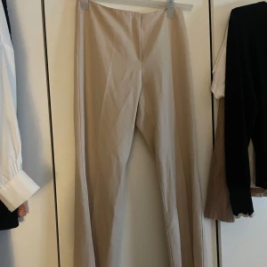 Beige byxor  - Snygga beige byxor från Les Sauterelles i en klassisk stil. De har en vid passform och är perfekta för både vardag och fest. Materialet känns mjukt och bekvämt, vilket gör dem till ett bra val för alla säsonger.