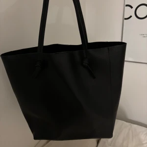 Svart axelväska - Snygg och stilren svart axelväska i skinn (ej äkta). Perfekt för vardagsbruk med gott om plats