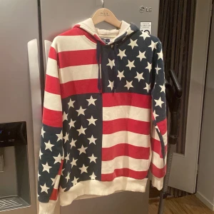Ralph Lauren hoodie - Säljer en svin snygg hoodie från Polo Ralph Lauren i storlek S. Den har ett amerikanskt flaggmönster med stjärnor och ränder i rött, vitt och blått. Perfekt för en avslappnad stil eller festliga tillfällen. Hoodien är i bra skick och superbekväm!