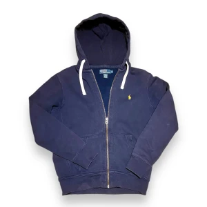 Ralph Lauren Hoodie - Säljer en Ralph Lauren zip-up hoodie i nyskick! Supermjuk och bekväm, perfekt både till vardags och för att klä upp en avslappnad look. Klassisk design med den lilla broderade Polo-loggan på bröstet.