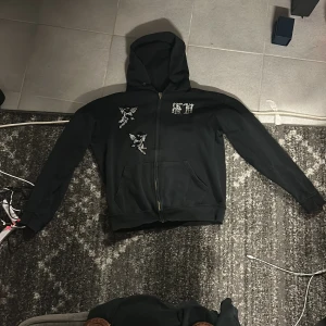 Svart hoodie med strassdetaljer - Säljer en svart hoodie från Bvaldi i storlek S.Perfekt för höst och vår när du vill ha något bekvämt men ändå stiligt. Passar både till vardags och festliga tillfällen.