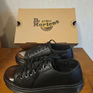 Säljer ett par unika svarta Dr. Martens sneakers i mycket bra skick. De har en klassisk design med snörning och en robust sula. Lägg märke till den silvriga detaljen på skons tåparti.    Perfekta för både vardag och fest.  Använda 1 gång. Storlek EU 36. Kommer i originalkartong.