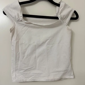 Vit kortärmad topp - Säljer en enkel och stilren vit topp med korta ärmar. Perfekt för sommardagar eller som basplagg i garderoben. Toppen är i bra skick och passar till många olika outfits.